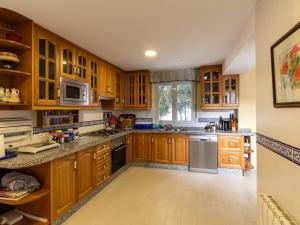 a kitchen with wooden cabinets and stainless steel appliances at Casa Mirador de Murchas in Murchas