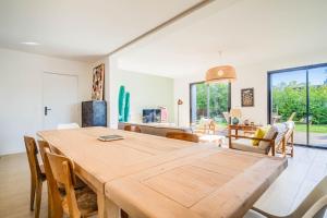 a dining room with a large wooden table and chairs at Belle maison moderne proche plages & bourg in Carnac