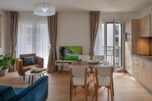 a living room with a couch and a table with chairs at Domitys Le 225 in Levallois-Perret