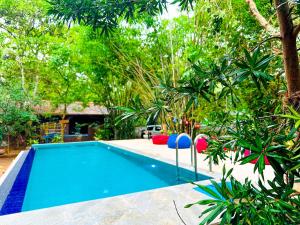 a swimming pool in a yard with trees at Jungle Host Hostel And Tree House in Sigiriya