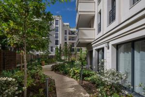 a walkway between two buildings with plants at Domitys Le 225 in Levallois-Perret