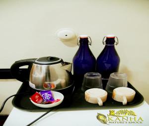 a tray with two blue vases and a tea kettle at Kanha Nature's Knock in Baihar