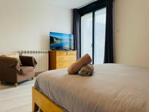 - une chambre avec un lit, une télévision et une chaise dans l'établissement Maison cosy Jardin des Plantes - 9 voyageurs - 388, à Rouen