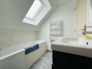 une salle de bain blanche avec un lavabo et une lucarne dans l'établissement Maison cosy Jardin des Plantes - 9 voyageurs - 388, à Rouen 48 autres photos