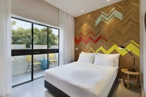 a bedroom with a bed and a wooden wall at Cucu Hotel in Tel Aviv