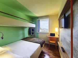 a bedroom with a bed and a desk with a window at ibis budget SP Centro Sao Joao in Sao Paulo +116 photos