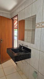 a bathroom with a black sink and a mirror at Rancho com acesso direto ao rio, área verde e lazer completo in Santa Fé do Sul