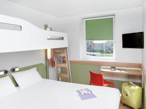 een slaapkamer met een bed, een bureau en een raam bij ibis Budget Clermont Ferrand Centre Montferrand in Clermont-Ferrand