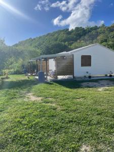 a white trailer with a garage in a field at Les gîtes Lanmou 1 in La Désirade