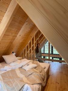 una mujer sentada en una cama en un ático en Leśny Chill House, en Grodziec