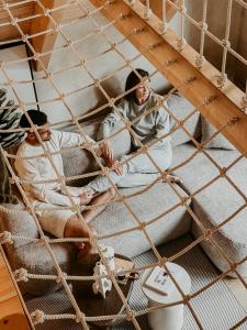 dos personas sentadas en la parte superior de las literas en Leśny Chill House, en Grodziec