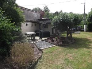a backyard with a picnic table and a tree at 43 Rue des Quarts in Ménesplet