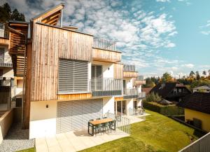un edificio de apartamentos con balcón y mesa en el patio en OpenSky Wörthersee Lodge, en Pörtschach am Wörthersee 120 fotos más
