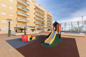 a playground with a slide in front of a building at Beachfront penthouse in La Manga in San Blas