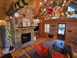 a living room with a fireplace and a christmas tree at Holiday Hideaway - Fire Pit, Hot Tub & Mountain Magic in Ellijay