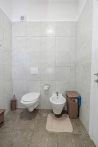 a white bathroom with a toilet and a bidet at Luxury Apartment with Parking in Tirana +25 photos