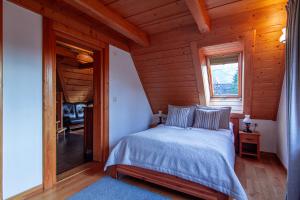 Un dormitorio con una cama en una cabaña de madera. en Rezydencja Na Szymoszkowej, en Zakopane