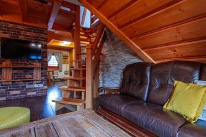 Una sala de estar con un sofá de cuero y un televisor. en Rezydencja Na Szymoszkowej, en Zakopane