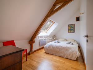 ein Schlafzimmer mit einem Bett auf einem Dachboden in der Unterkunft Bulle de calme bucolique - jardin & piscine privée in Fercé-sur-Sarthe + 30 Fotos