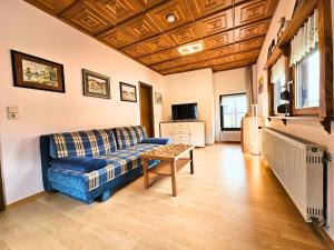 a living room with a blue couch and a table at Ferienwohnung an der Altmühl - Apartment Gerda in Pappenheim