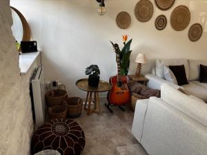 a living room with a guitar and a couch at Bracken Cottage in Weymouth