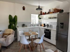 a kitchen with a table and chairs and a refrigerator at Bracken Cottage in Weymouth