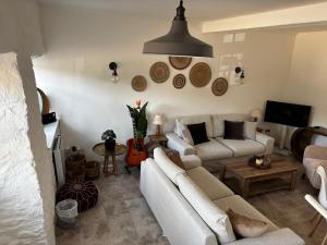 a living room with two couches and a tv at Bracken Cottage in Weymouth +3 photos