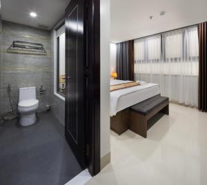 a bathroom with a bed and a shower and a toilet at Berlin Haus Nha Trang Hotel in Nha Trang +28 photos