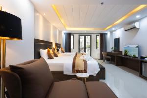 a hotel room with a bed and a couch at Berlin Haus Nha Trang Hotel in Nha Trang