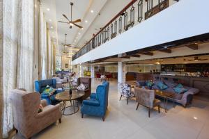 Un vestíbulo con sillas y mesas azules y un bar. en Sơn Nữ Emerald Hill Hotel, en Bak Kan