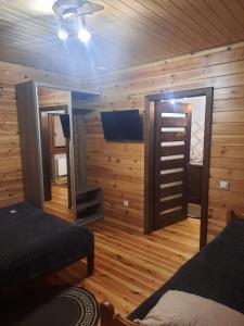 スヴィチャスにあるSopko restの木製の壁と鏡とテレビのある寝室