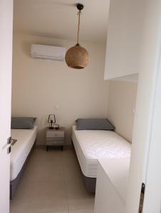 a bedroom with two beds and a light fixture at Apartment Odysea in Plataniás +3 photos