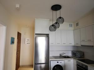 a kitchen with a stainless steel refrigerator and white cabinets at Apartment Odysea in Platanias +3 photos