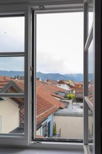 an open window with a view of roofs at ღLiboria Villa Münter in Murnau am Staffelsee