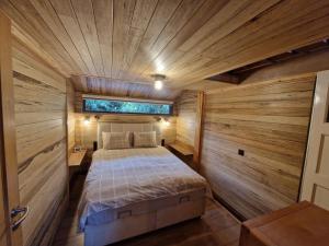 a bedroom with a bed in a room with wooden walls at Het boothuis in Velden