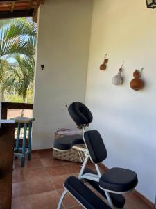 a room with a chair and a table and a window at Pousada Farol do Marinheiro in Boicucanga
