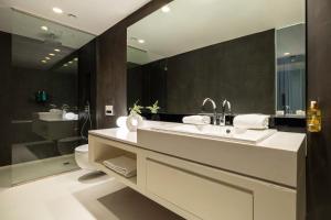 een badkamer met een wastafel, een toilet en een spiegel bij B-aparthotel Regent in Brussel +36 foto's