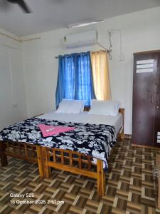 Cama en habitación con cortinas azules en New Paradise Inn, en Varkala 1 foto más