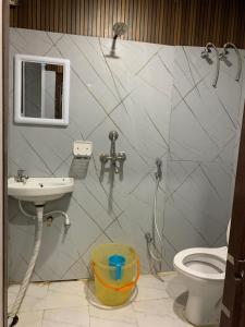 een badkamer met wastafel en toilet bij Hotel Aaghnya in Guwahati