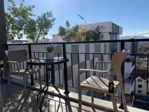 ein Balkon mit zwei Stühlen und einem Tisch auf einem Balkon in der Unterkunft Tirana Magnifique Apartments in Tirane