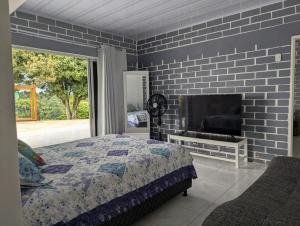 a bedroom with a large bed and a tv at La Bella Vista in Calarcá