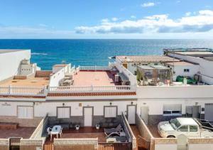 a white building with the ocean in the background at Playa Azul Amplio y luminoso con vistas al mar in Pozo Izquierdo