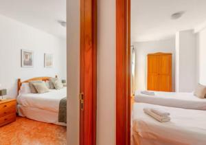 a bedroom with two beds and a doorway with a mirror at Playa Azul Amplio y luminoso con vistas al mar in Pozo Izquierdo