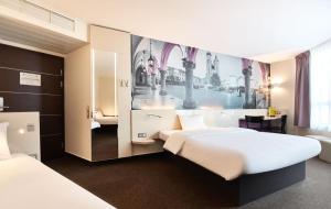 Una cama o camas en una habitación de B&B HOTEL Krakow Centrum 53 fotos más