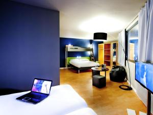 a room with a bed and a laptop on a couch at ibis budget Brest Centre Port in Brest