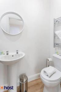 a bathroom with a toilet and a sink and a mirror at The residency rooms walton in Walton on the Hill +14 photos