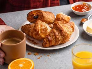 a plate of pastries on a table with a cup of coffee at ibis budget Thonon Les Bains in Thonon-les-Bains +40 photos