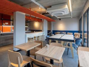 Un restaurante con mesas y sillas y una cocina. en IBIS Budget Pontivy, en Pontivy