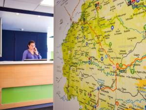 Un hombre en una oficina hablando sobre un mapa en ibis budget Rodez, en Rodez