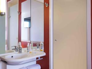 a bathroom with a sink and a mirror at Ibis Budget Lyon Centre - Gare Part Dieu in Lyon +37 photos